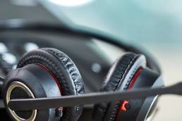 Close-up of a headset lying near a phone on a desk.