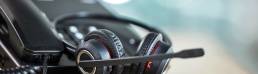 Close-up of a headset lying near a phone on a desk.