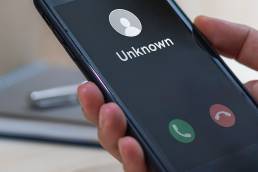 Close-up image of a smartphone receiving a call from an unknown number.